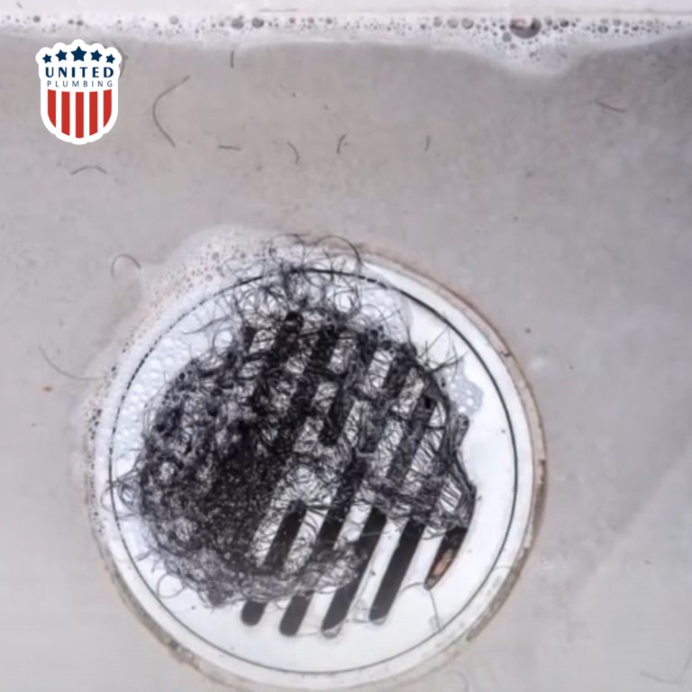 Close up of debris being removed from a shower drain