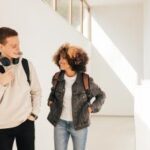 Young man and young woman in hallway talking and smiling