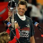 Tom Brady celebrating a Super Bowl victory with the Vince Lombardi trophy.