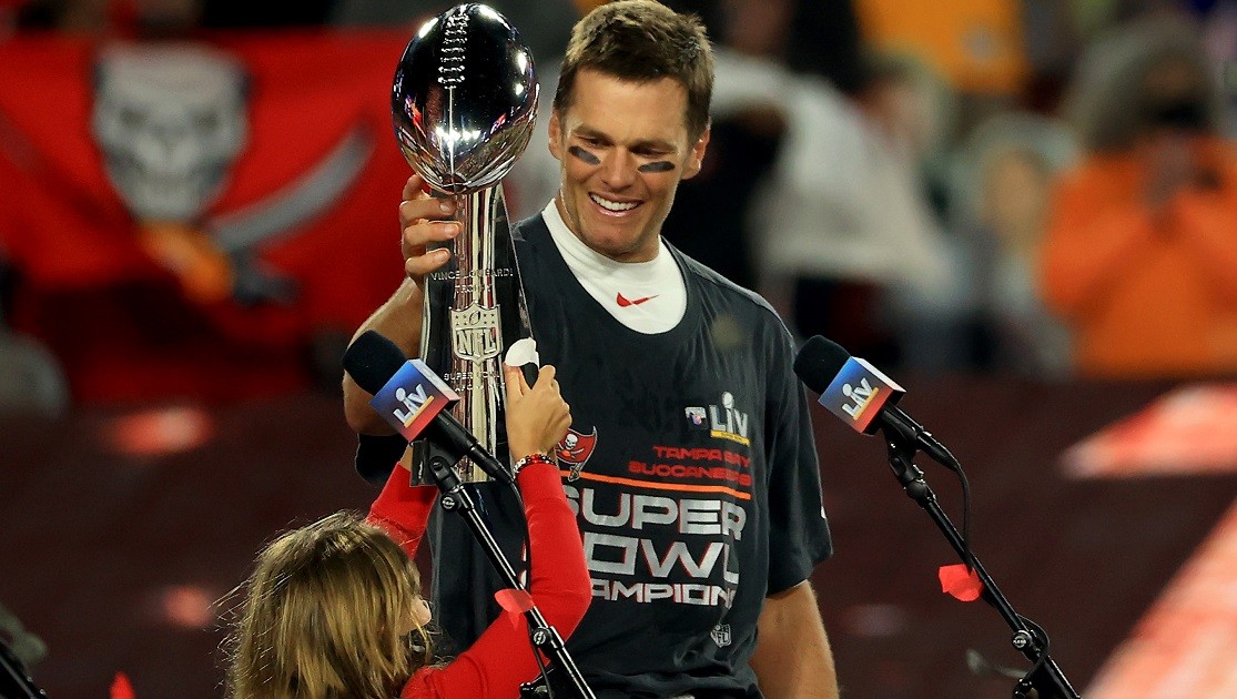 Tom Brady celebrating a Super Bowl victory with the Vince Lombardi trophy.