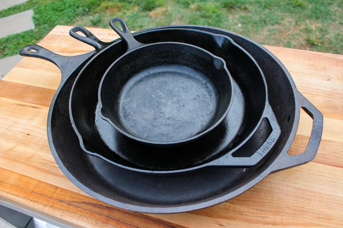 Stack of seasoned cast iron skillets ready for cooking.