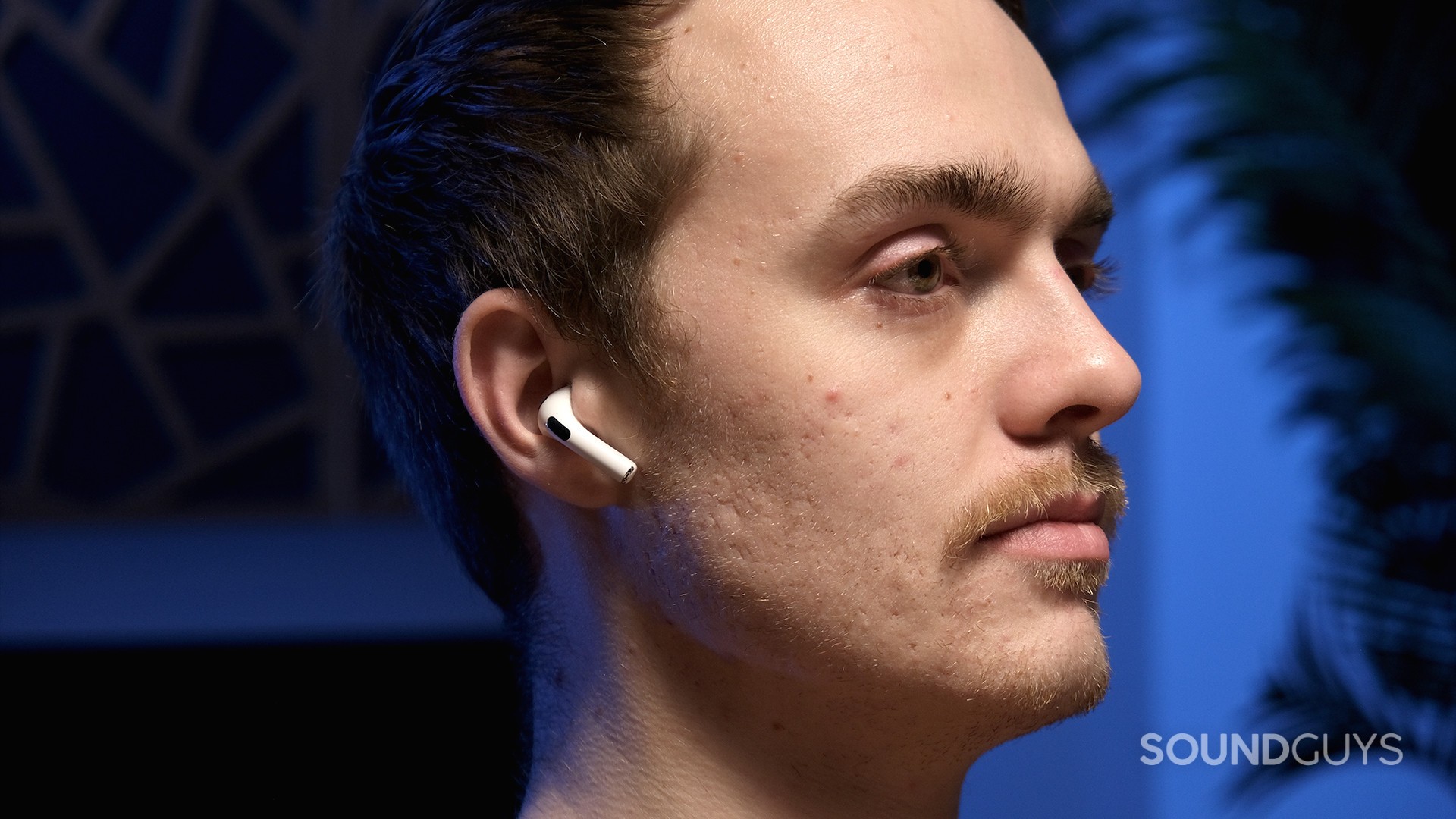 A person wearing white AirPods (3rd generation) with a blue background, demonstrating their everyday use.