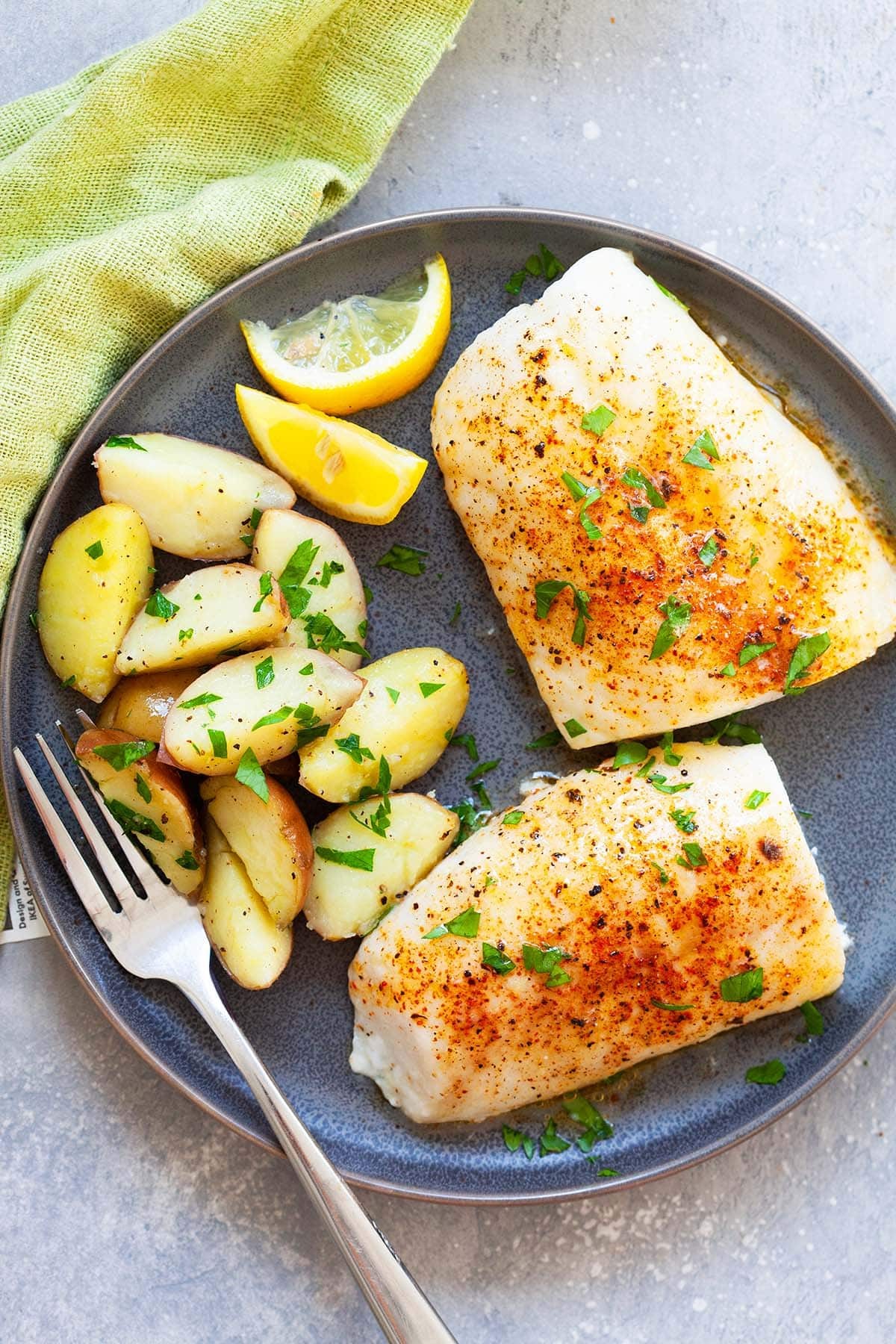 Baked cod served with boiled potatoes, highlighting a simple and healthy meal idea.