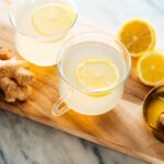 Freshly made ginger tea in a clear glass mug, showcasing the golden color of the beverage. Learn how to make ginger tea at home.