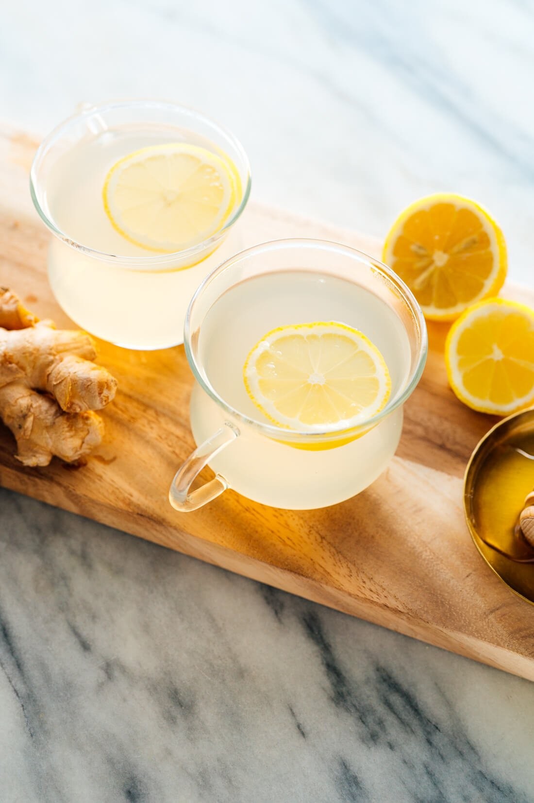 Freshly made ginger tea in a clear glass mug, showcasing the golden color of the beverage. Learn how to make ginger tea at home.