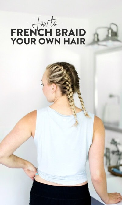 A young woman with blonde hair showcasing neatly done French braid pigtails.