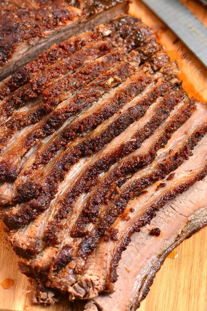 Close-up of sliced beef brisket on a wooden cutting board, showcasing its juicy and tender texture.