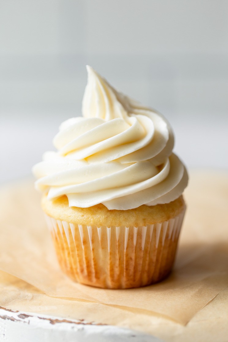 A close-up of a perfectly piped buttercream frosting swirl on a cupcake, showcasing its smooth texture and defined edges.