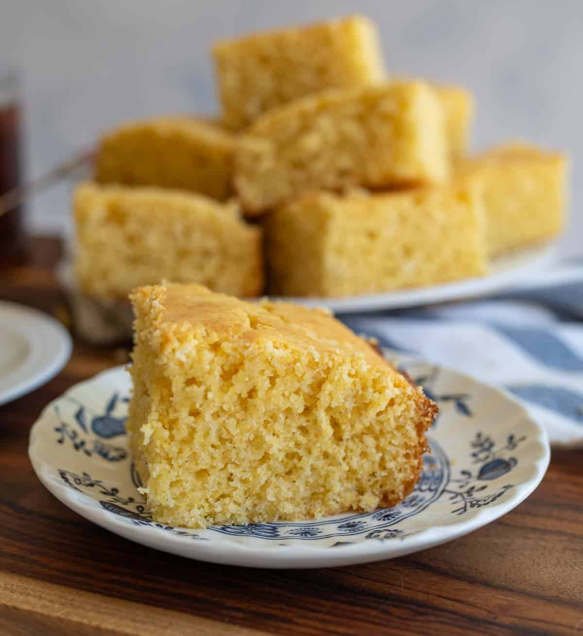 Slice of cornbread on a plate, showcasing its moist and crumbly texture.