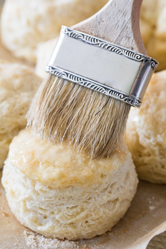 Brushing melted butter on a freshly baked homemade biscuit