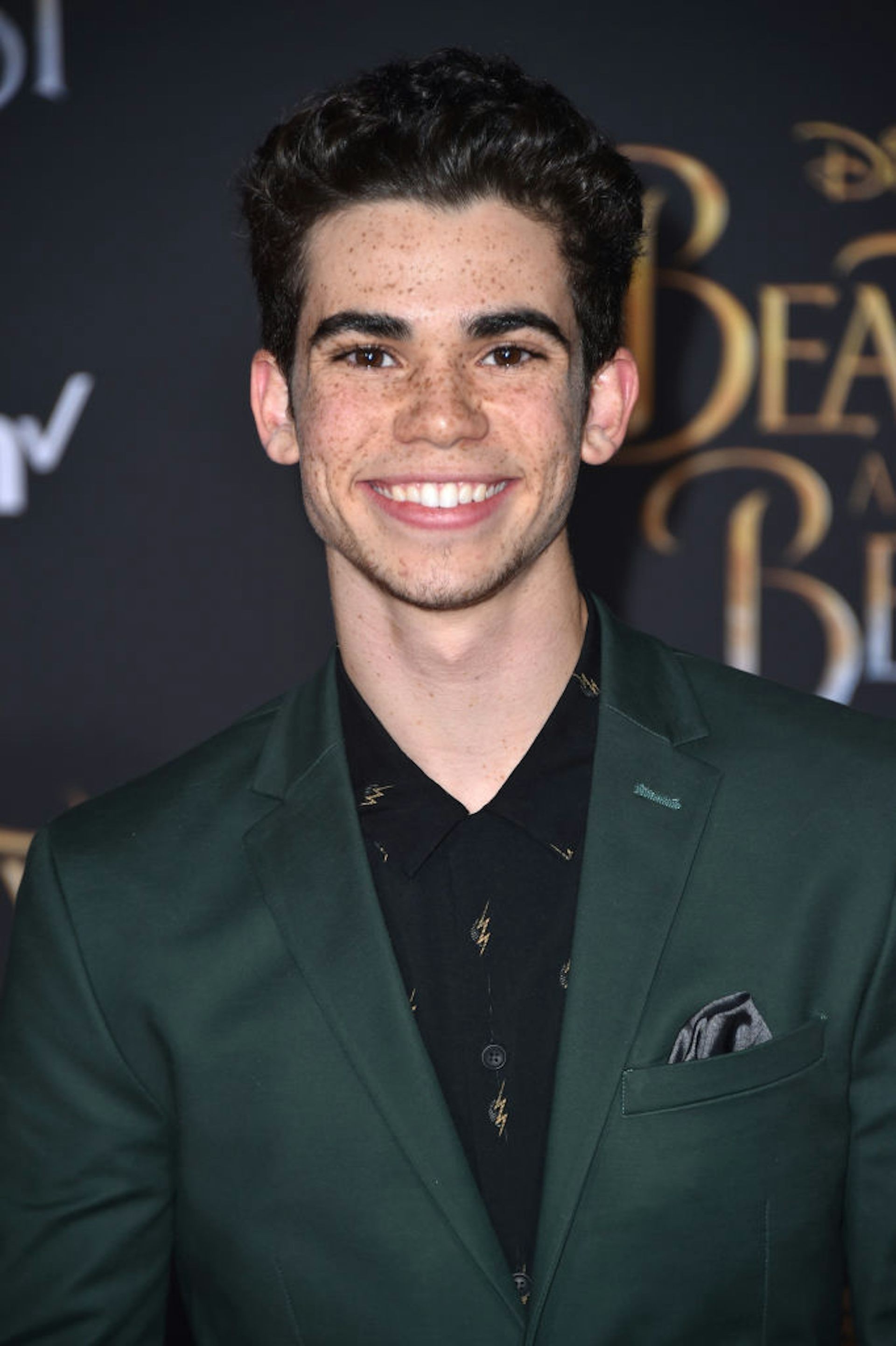 Cameron Boyce in suit smiling at camera.