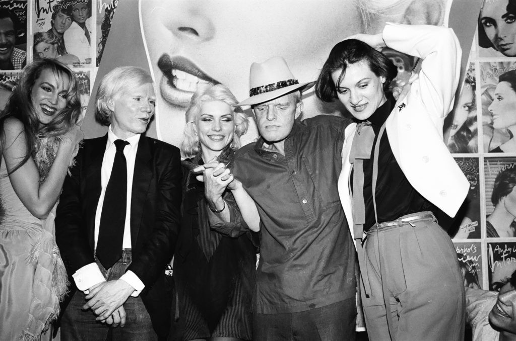 Truman Capote at Studio 54 in 1979 with Jerry Hall, Andy Warhol, Debbie Harry, and Paloma Picasso, reflecting his lifestyle of fame and excess that contributed to his declining health and eventual death from liver disease and drug intoxication.