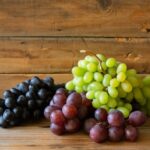 A variety of red, green, and black grapes are displayed, highlighting their identical nutritional value.