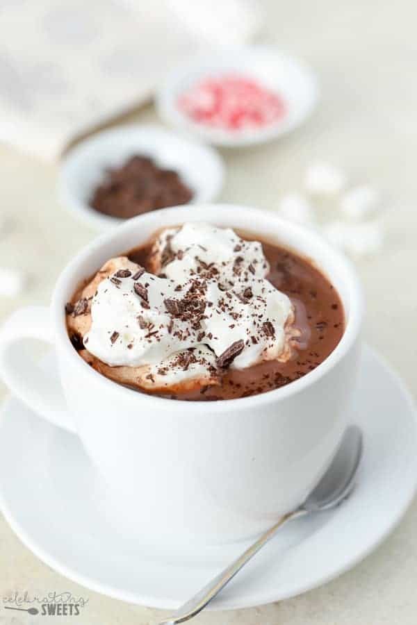 Creamy homemade hot chocolate in mugs, topped with whipped cream and chocolate shavings.