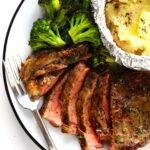 Close-up of a perfectly cooked steak with a crispy crust, resting on a wooden cutting board, showcasing the juicy interior.