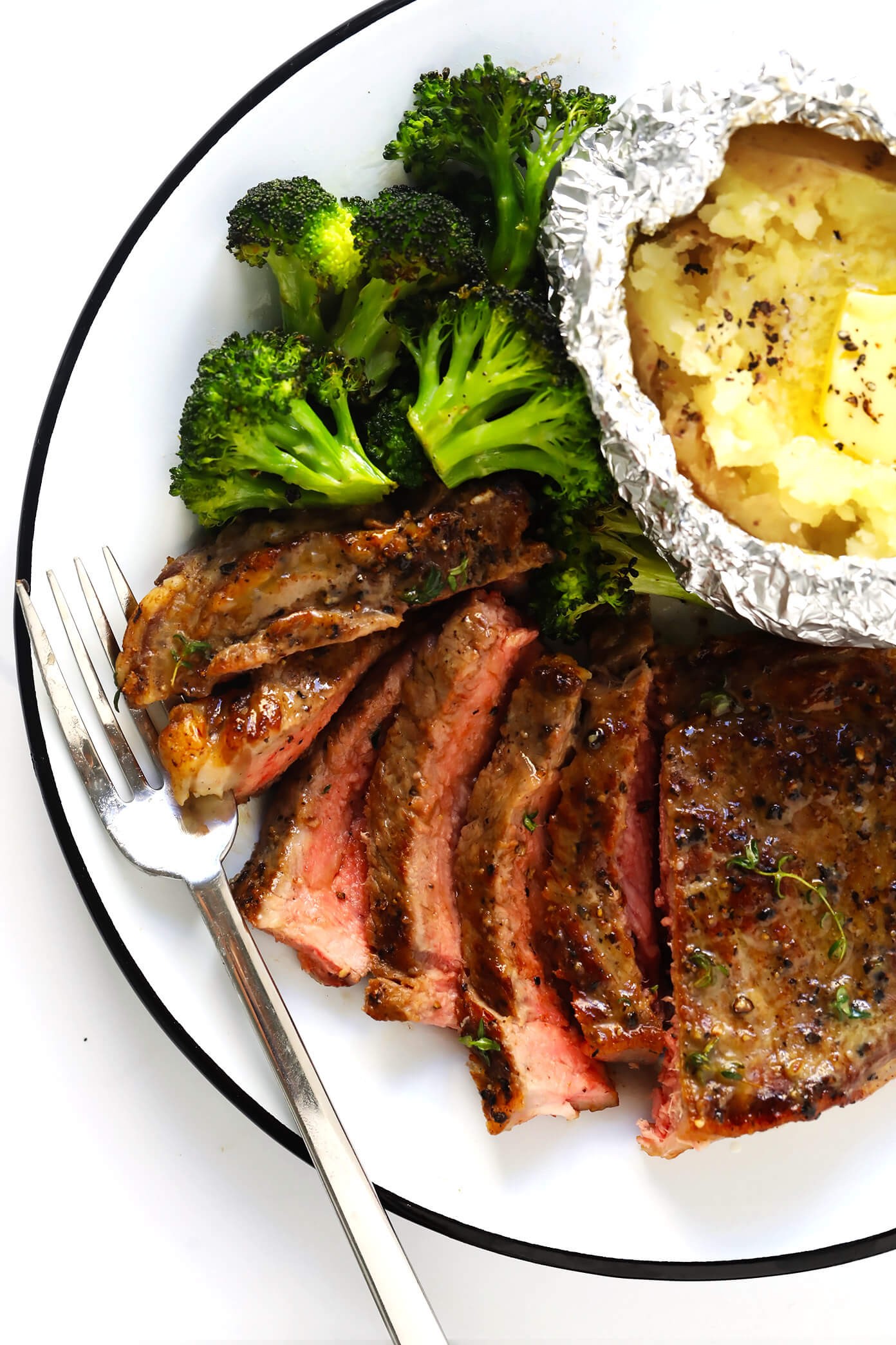 Close-up of a perfectly cooked steak with a crispy crust, resting on a wooden cutting board, showcasing the juicy interior.