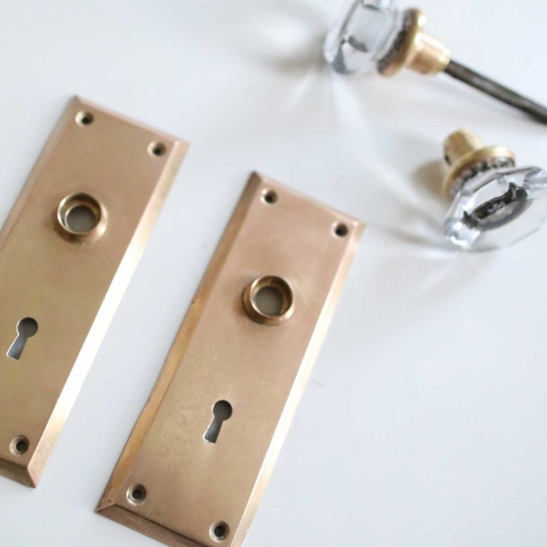 Close-up of a brass doorknob being cleaned with Bar Keepers Friend and a sponge