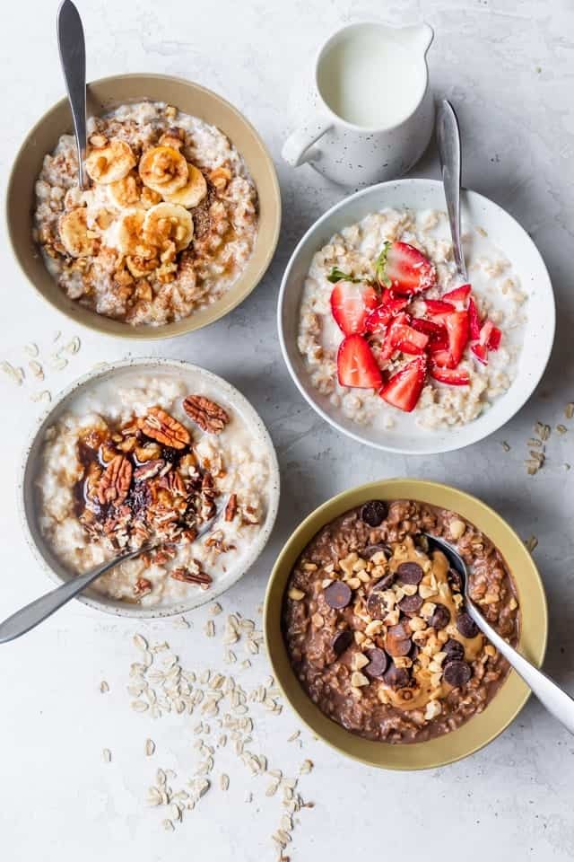 Variety of oatmeal bowls with different toppings like fruits and nuts