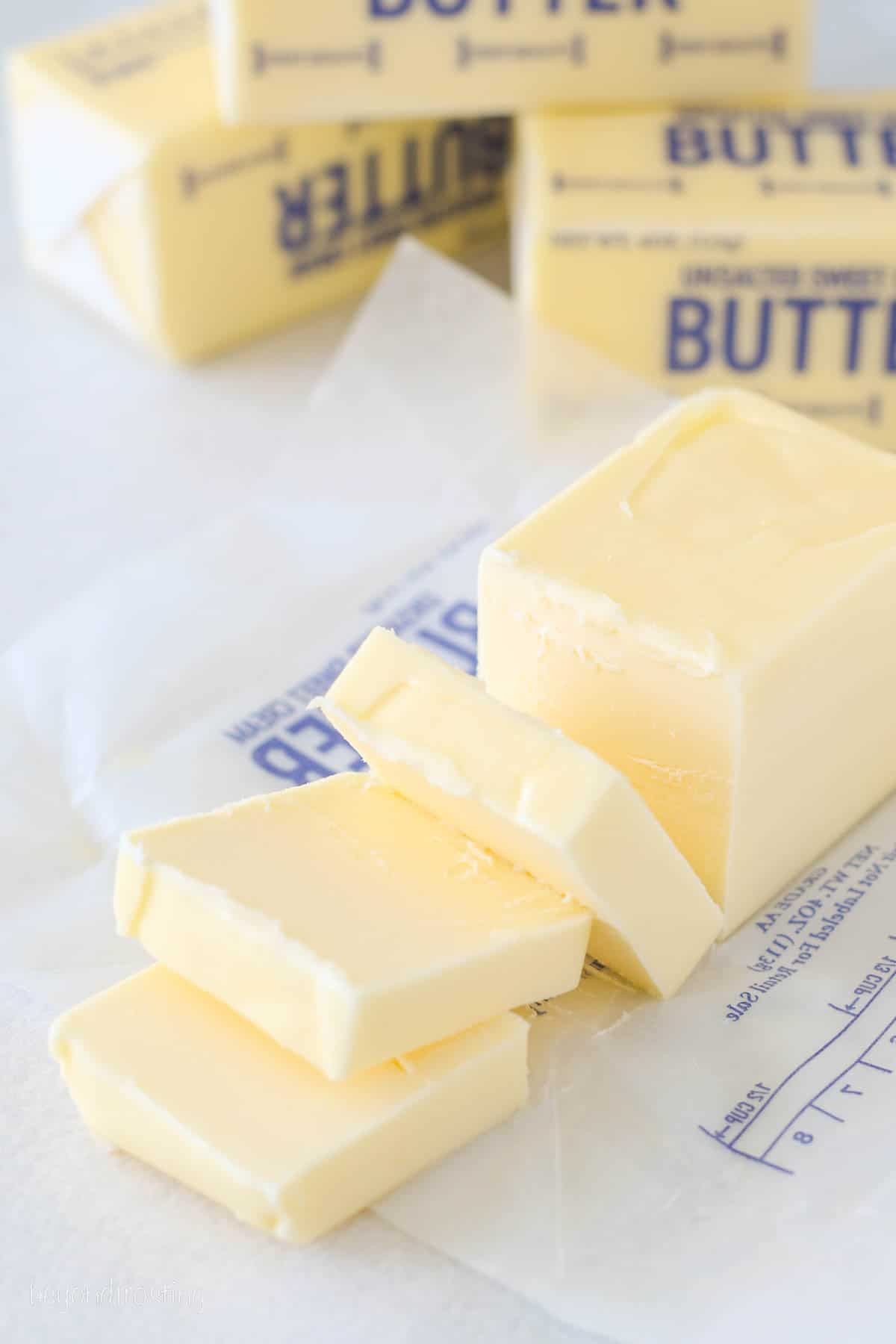 An unwrapped stick of butter sliced into squares, illustrating tablespoon measurements.