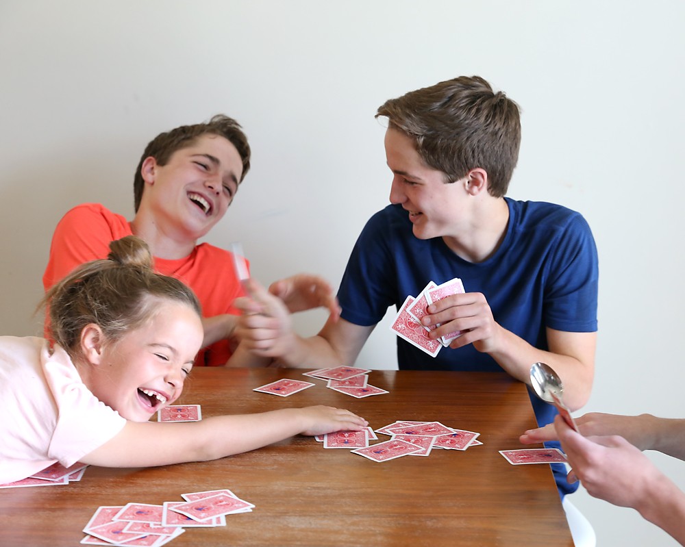 kids laughing playing spoons card game