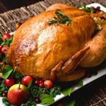 Close-up shot of a raw turkey in a roasting pan, ready to be cooked.