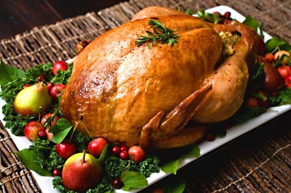 Close-up shot of a raw turkey in a roasting pan, ready to be cooked.