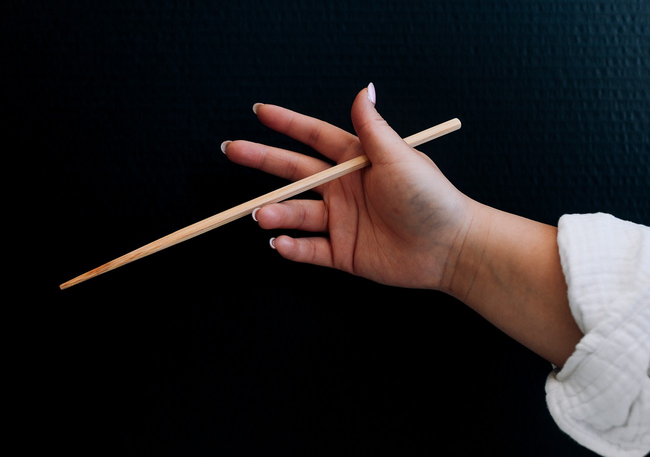 holding chopsticks between thumb and forefinger and resting on ring finger