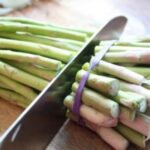 Fresh asparagus spears prepared for roasting, showcasing their vibrant green color and trimmed ends.