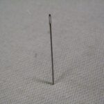 Needle secured in fabric for one-handed threading