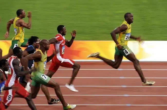 Athlete sprinting on a track, showcasing powerful leg muscles and focused determination.