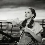 Judy Garland as Dorothy in The Wizard of Oz, highlighting the young age at which she faced exploitation in Hollywood.