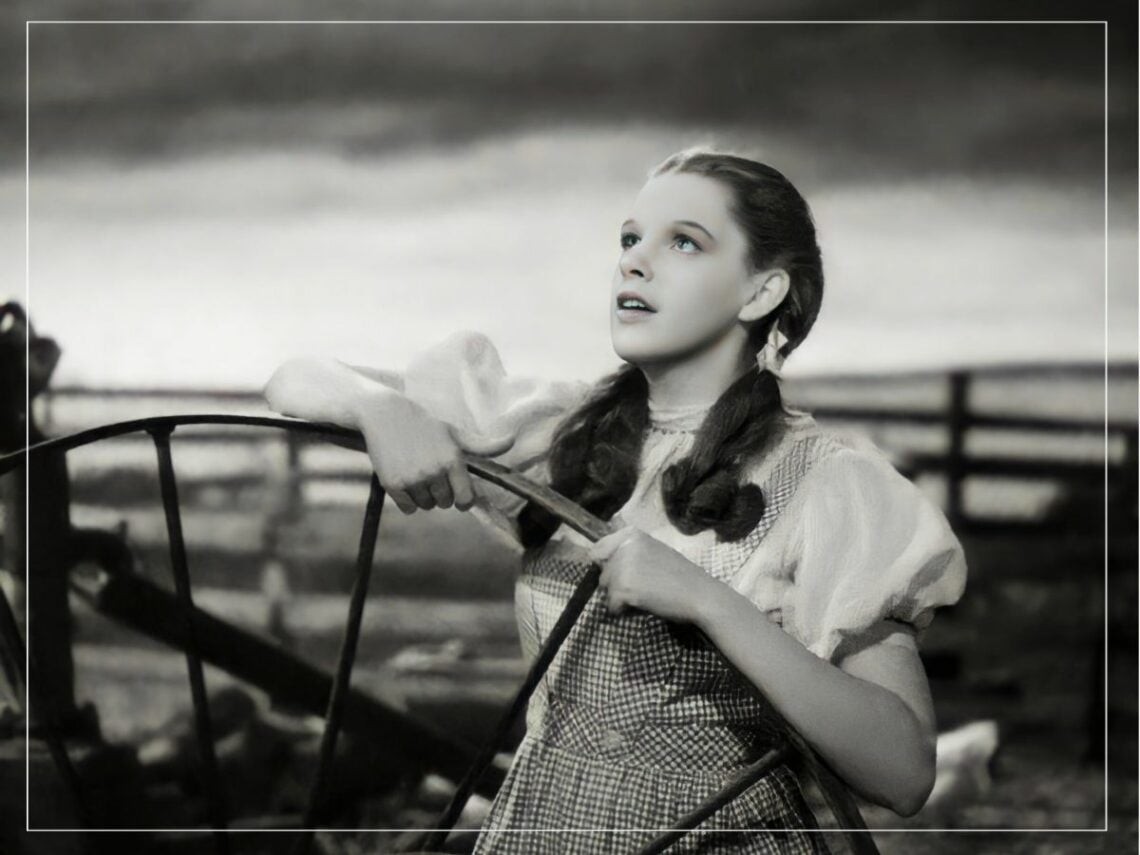 Judy Garland as Dorothy in The Wizard of Oz, highlighting the young age at which she faced exploitation in Hollywood.