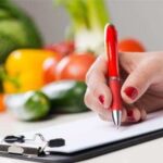 Nutritionist writing food in background, illustrating healthy diet choices for managing creatinine levels