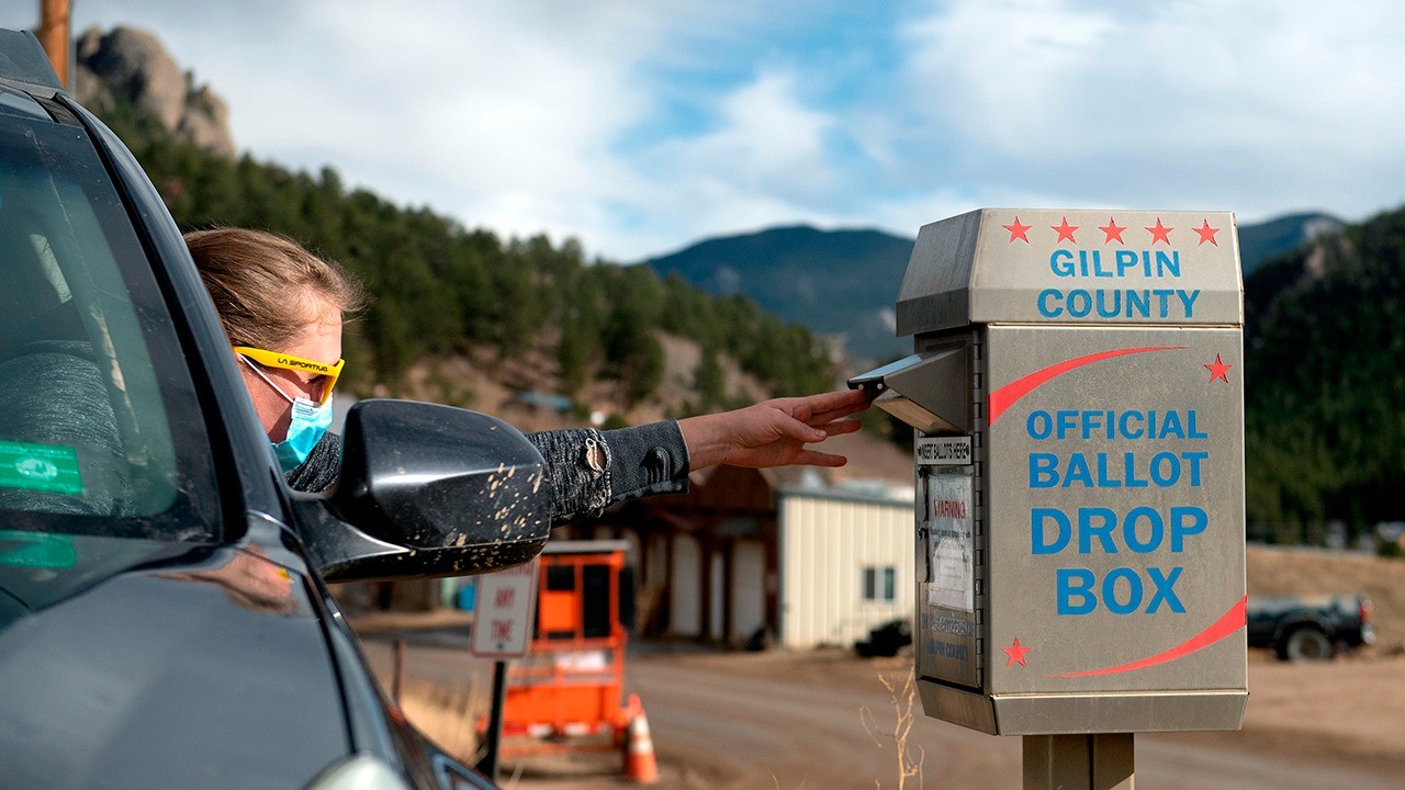 Steph Smith drops off her ballot for the 2020 presidential election in Rollinsville, Colorado, highlighting the accessible voting process and citizen participation.