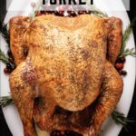 Whole smoked turkey presented on a platter, showcasing its rich, dark, and smoky exterior.