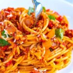 Close-up of spaghetti with meat sauce, showcasing the texture and richness of the sauce