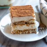 A slice of homemade tiramisu on a white plate.