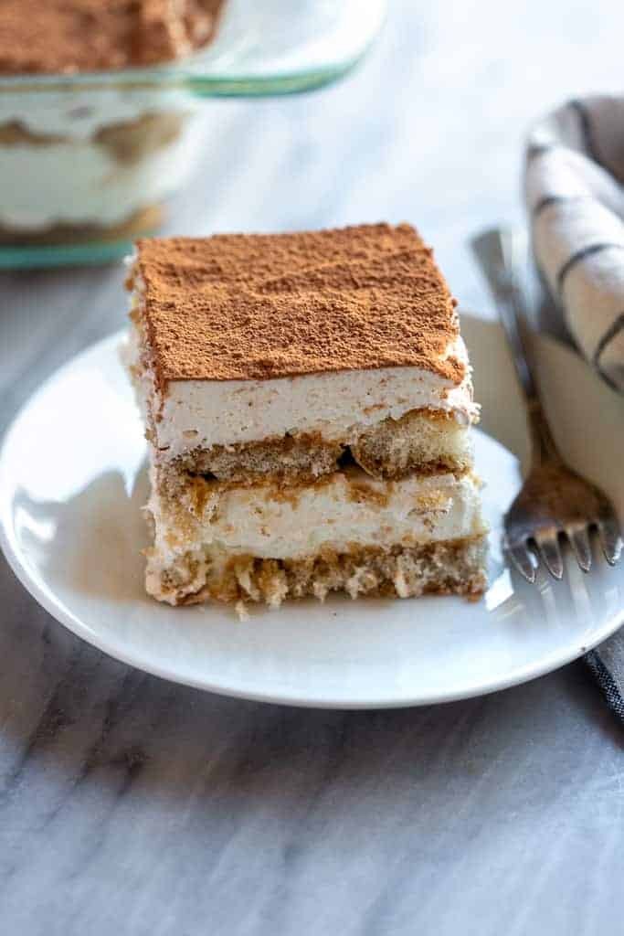 A slice of homemade tiramisu on a white plate.