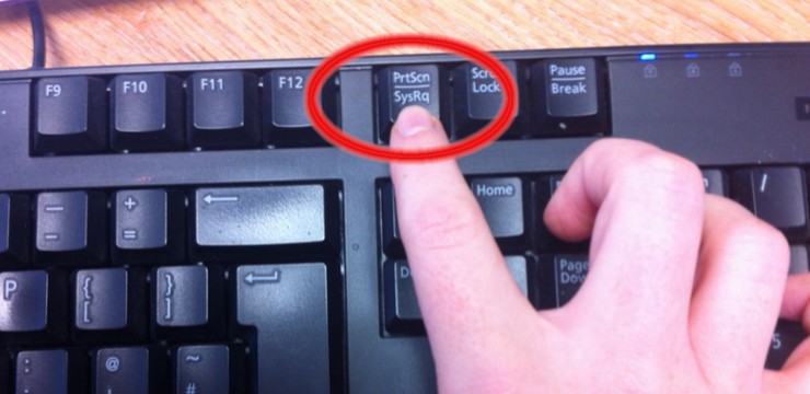 Pressing the Print Screen (PrtScn) key on a Windows keyboard to take a screenshot of the entire screen