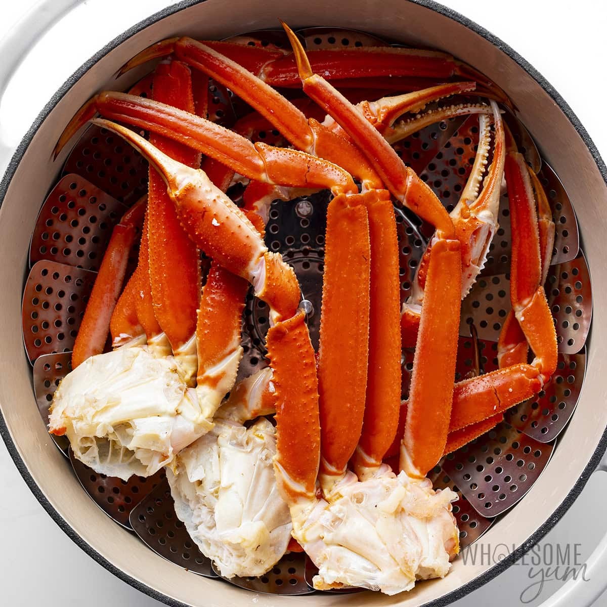 Steamed crab legs in a pot with a steamer basket.