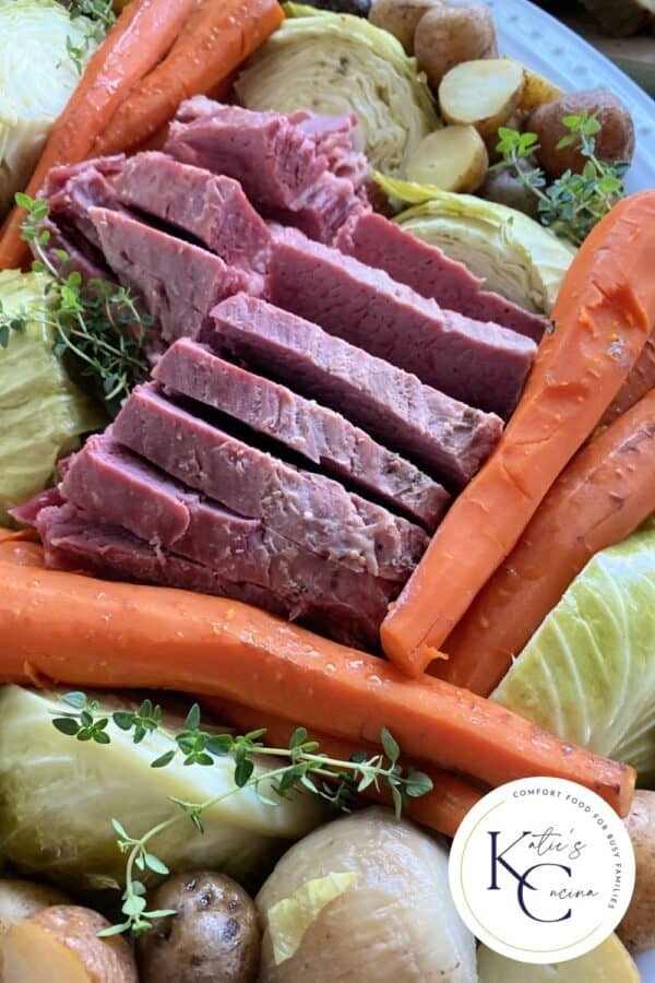 Close up of a platter of corned beef, cabbage, carrots, and potatoes, showcasing the dish's rich and flavorful appearance.