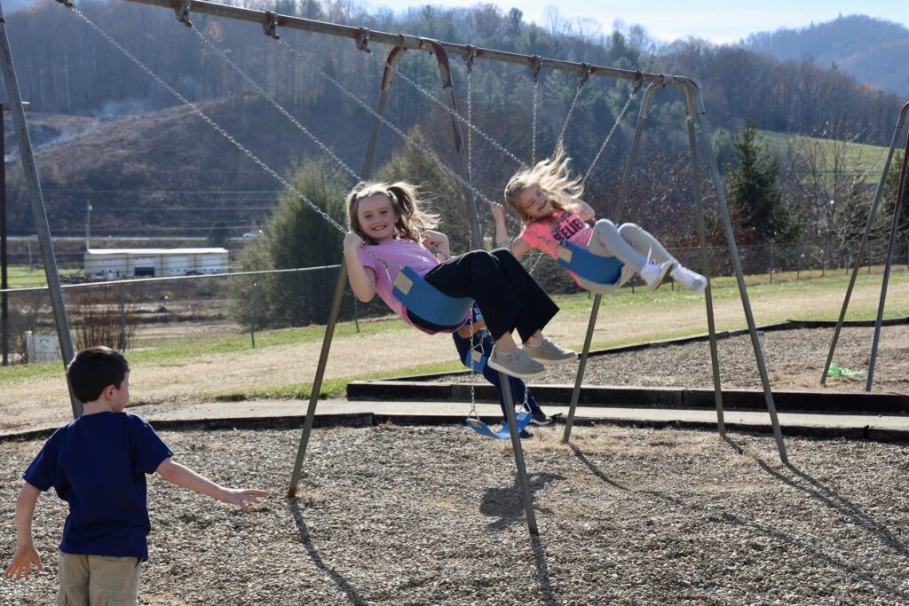 Swinging on the first day back at school in Yancey County, students return after Hurricane Helene
