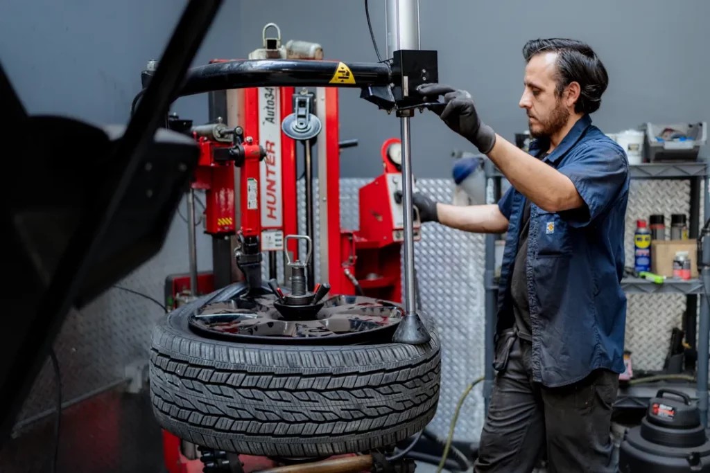 A technician using a tire balancing machine to ensure a tire is properly balanced, ensuring smooth and safe driving.