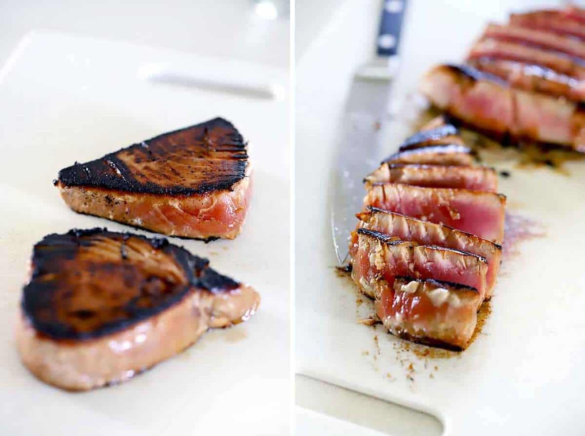 A sesame-crusted tuna steak, showcasing the golden-brown crust and the contrast with the pink interior, served with a side of green salad.