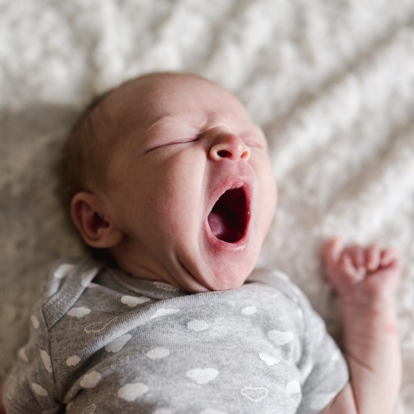 can babies sleep to0 much, yawning sleeping baby on blanket