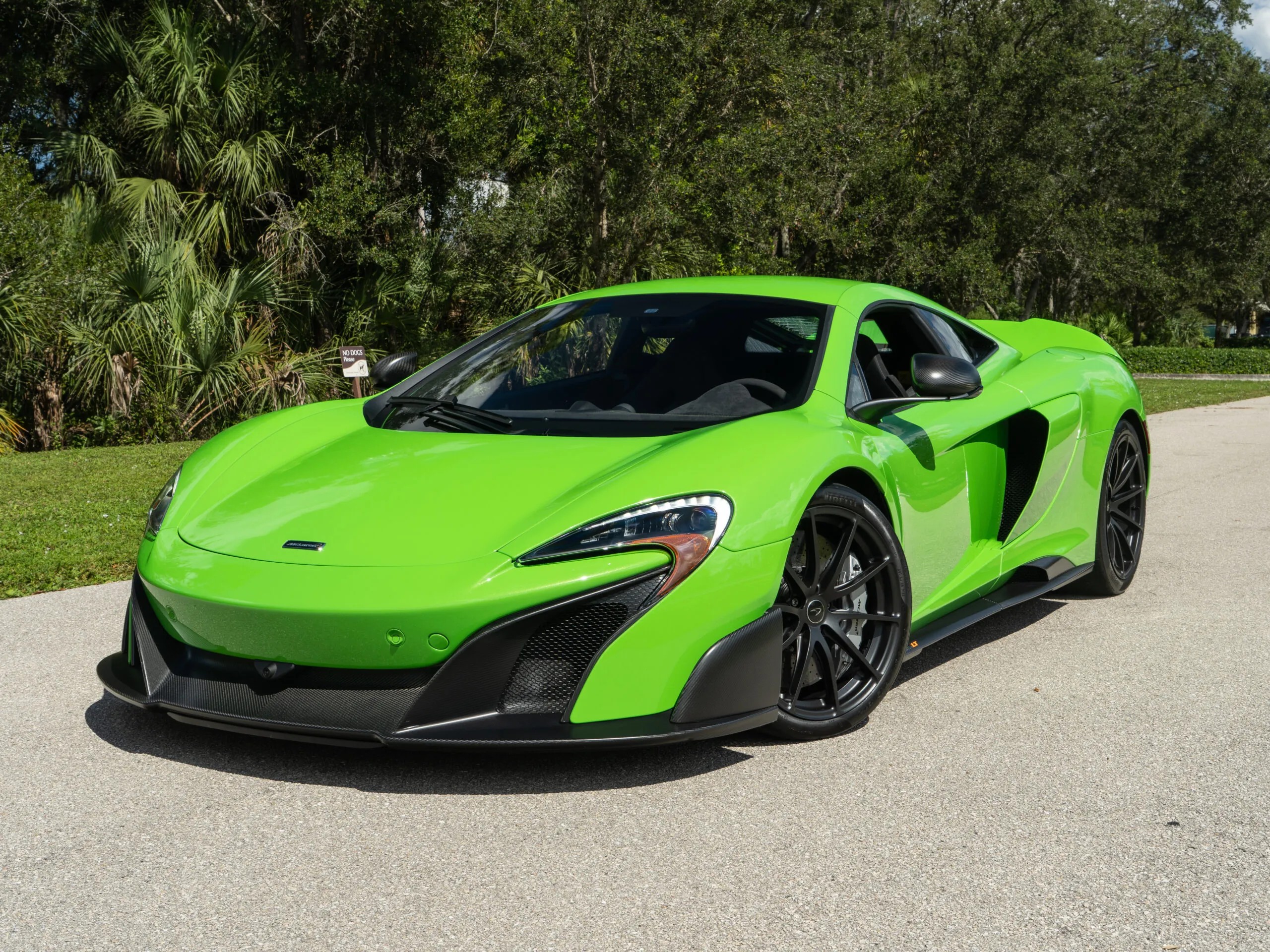 A green McLaren 650s parked outdoors showing its sleek design