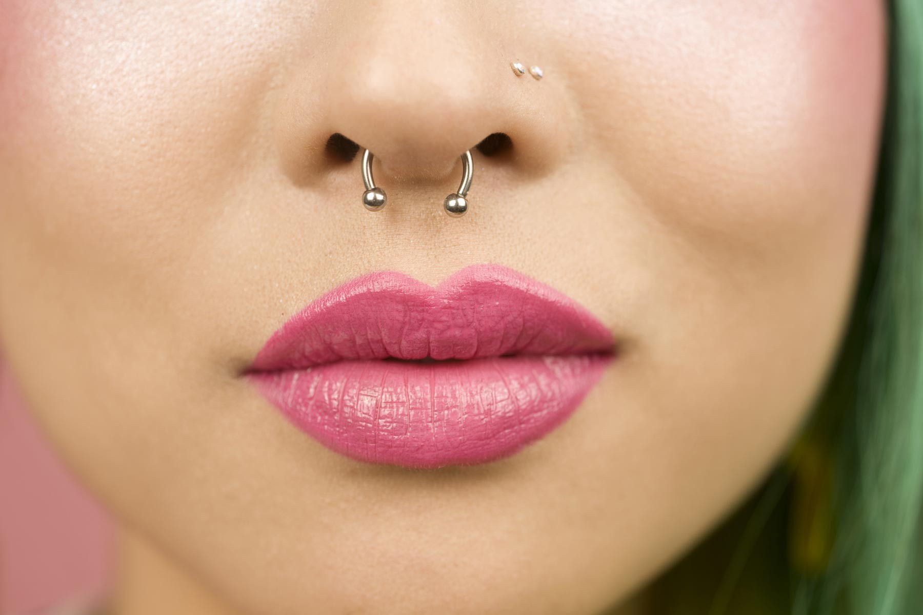 Woman with nostril and septum piercings