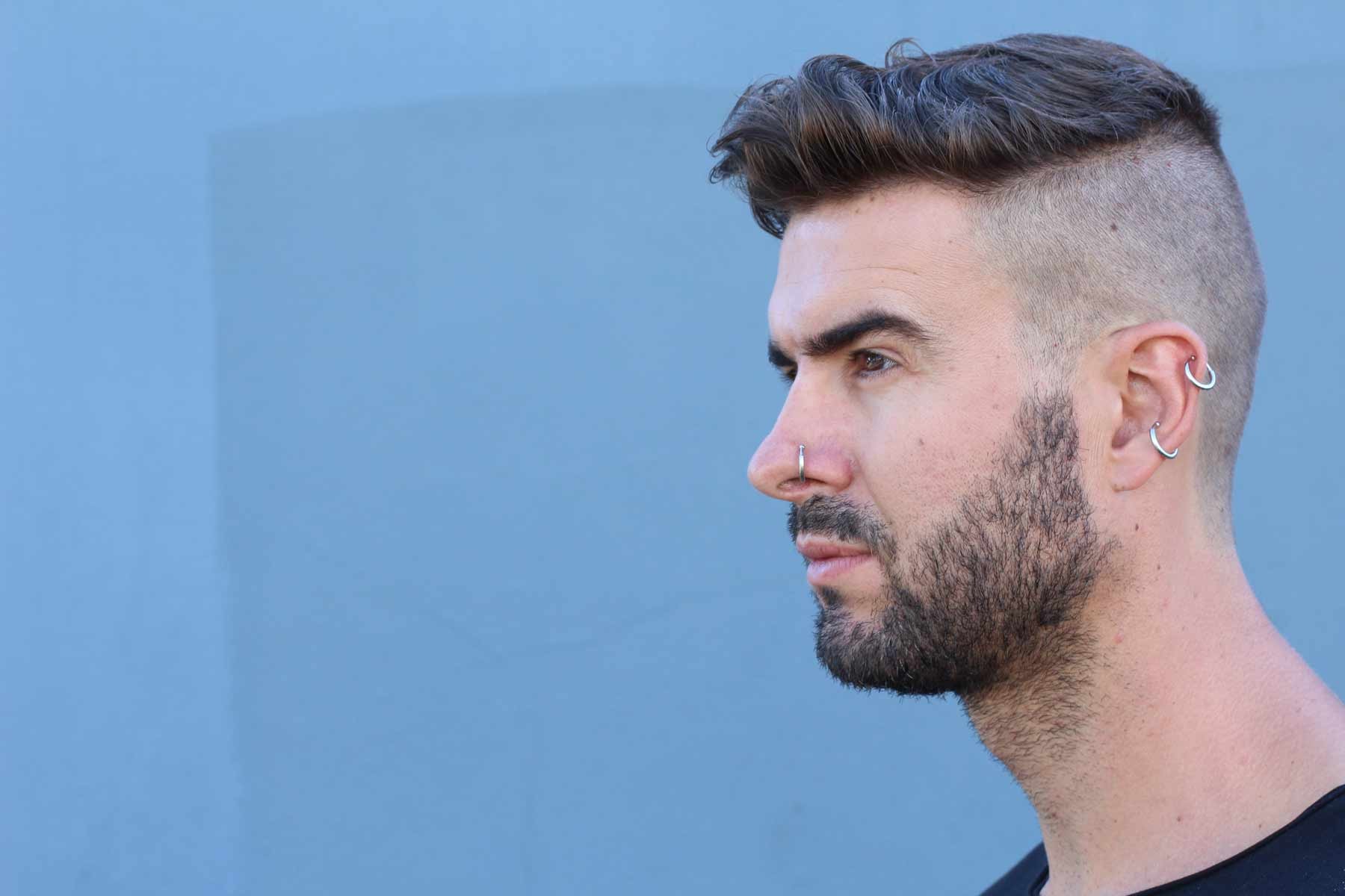 Young man with ear and nose piercings