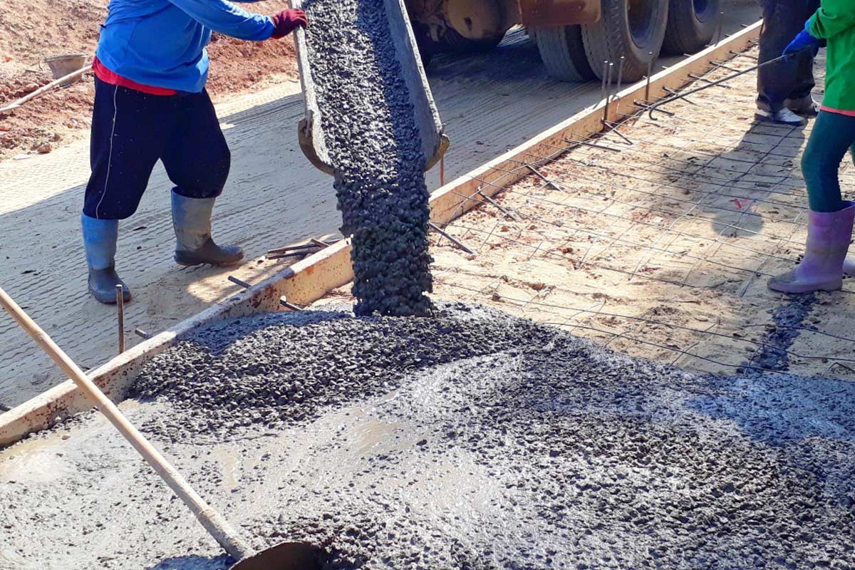 Workers pouring ready mix concrete