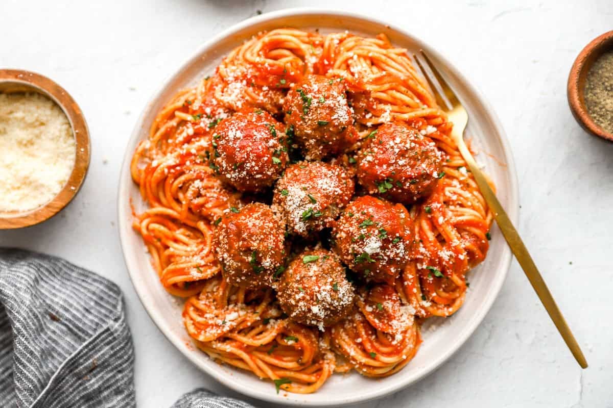 Overhead view of homemade meatballs, marinara sauce, and spaghetti on a plate.